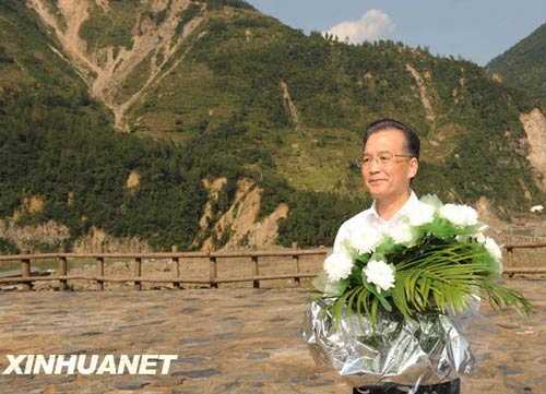 溫家寶總理十分關(guān)注災(zāi)后重建進(jìn)展情況。在國慶節(jié)和中秋佳節(jié)即將來臨之際，他第8次踏上了一直牽掛的這塊土地。在9月24日至26日的三天時間里，他奔波穿行于地震重災(zāi)區(qū)的城鄉(xiāng)間，為節(jié)省時間，吃飯盡量安排在火車上；連續(xù)兩個晚上主持召開會議，就災(zāi)后恢復(fù)重建的一系列重大問題進(jìn)行研究部署。這是9月24日，溫家寶在青川縣紅光鄉(xiāng)東河口村地震遺址祭奠臺獻(xiàn)花。新華社記者黃敬文攝