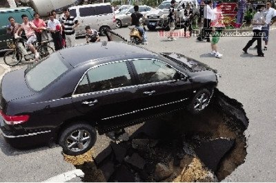 4日，南昌市昌南大道與迎賓北大道交叉口附近路面突然發(fā)生塌陷，一輛過(guò)路小轎車(chē)被卡在洞口處。圖/新華社