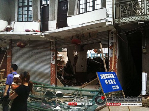 大成橋鎮(zhèn)老街，16號門面，房梁垮塌、房屋變形，門前的卷閘門已是一邊高一邊低。 圖/瀟湘晨報(bào)滾動(dòng)新聞?dòng)浾?劉剛