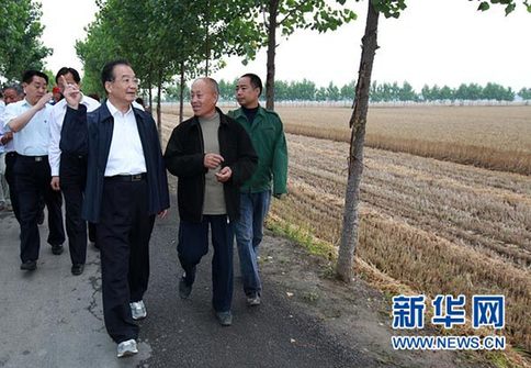 這是6月9日，溫家寶在長葛市石象鄉(xiāng)坡李王村的田間小路上與坡李王村支部書記李福成邊走邊聊。新華社記者龐興雷攝