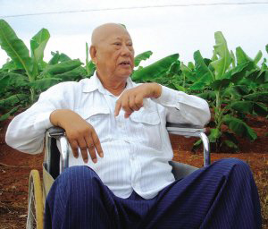 陳光保在自己的農場里，他身后就是一片香蕉林(中青報蔣昕捷供圖)