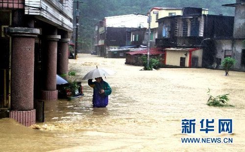 10月21日，臺(tái)灣宜蘭縣蘇澳地區(qū)居民在洪水中艱難出行。新華社發(fā) 