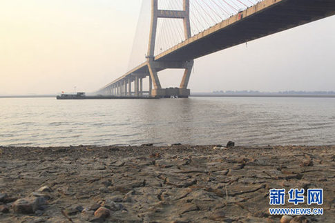 這是12月10日在江西省湖口縣境內(nèi)的鄱陽湖大橋附近拍攝的已經(jīng)干涸開裂的湖灘。