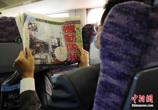 3月17日下午，在一列前往東京的新干線列車上，一名日本人在閱讀關(guān)于福島核電站三號機組最新狀況的報道。中新社發(fā) 侯宇 攝