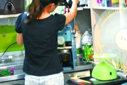 昨日，沙坪壩區(qū)一飲料店，店員在用添加劑勾兌果汁