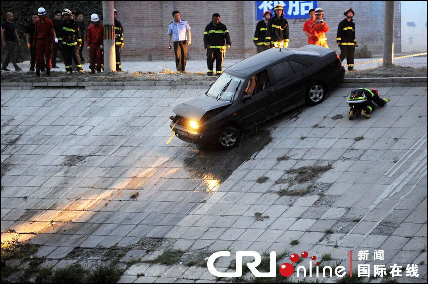 2012年6月17日下午，北京四元橋下方的西壩河輔路上，一輛轎車失控墜河中。消防員將轎車拖上岸。