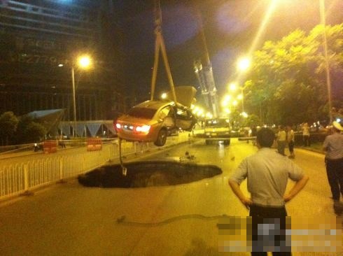 吊車將墜入塌陷坑的汽車吊出。圖/末代小王爺
