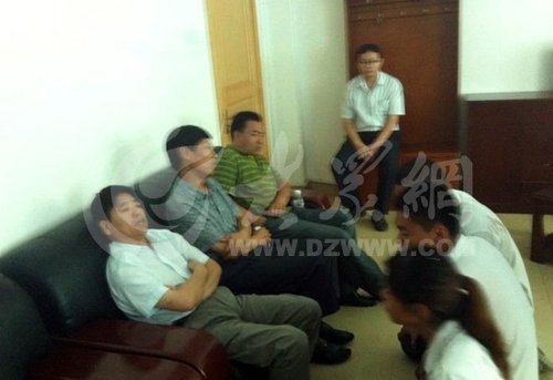 在壽光市人民醫(yī)院接待室，3名死者家屬向院方人員下跪，院方人員表情漠然。