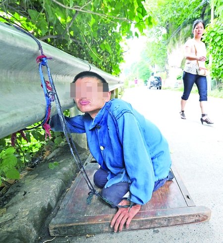 江津白沙鎮(zhèn),被捆在公路邊的何貴明。 首席記者 鐘志兵攝