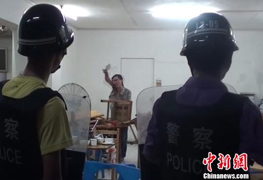 圖為涉嫌販毒的男子持菜刀在宵夜店與民警對峙。 劉志強(qiáng) 攝