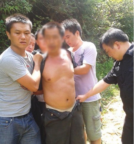 8月19日，“8.17”特大命案犯罪嫌疑人龍某某被保靖民警押到山下(圖片由保靖縣公安局提供)