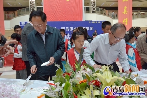 市委常委、宣傳部長(zhǎng)胡紹軍與青島報(bào)業(yè)傳媒集團(tuán)總編輯蔡曉濱為讀者切蛋糕
