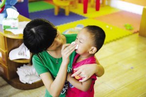 2012年9月3日，浙江一所幼兒園，老師幫孩子擦鼻涕。