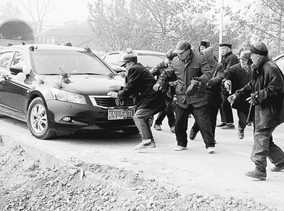 一些老人蜂擁而上圍堵婚車。