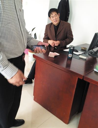 10月29日，獻(xiàn)縣國稅局稽查局辦公室內(nèi)，一名企業(yè)主交了兩萬元現(xiàn)金在桌上。新京報記者 孟祥超 攝