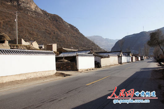 甘肅漳縣殪虎橋鄉(xiāng)東橋村，一排已經粉刷過的“遮羞墻”（人民網記者 高翔 張鵬 隋欣 攝）
