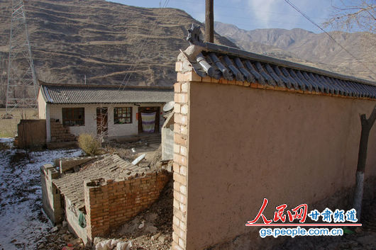 甘肅漳縣殪虎橋鄉(xiāng)東橋村的“遮羞墻”擋住農戶房屋（人民網記者 高翔 張鵬 隋欣 攝）