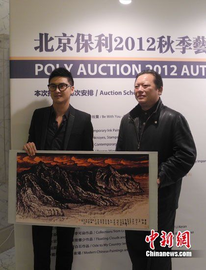 田亮與畫家洪潮合影，兩人展示《夢縈釣魚島》縮小版。