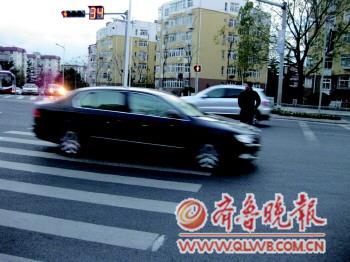 一位行人在燕兒島路與寧夏路路口闖紅燈被困在車(chē)流中。