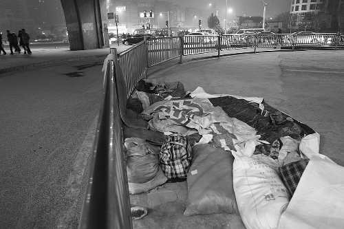 農(nóng)民工露宿地的不遠(yuǎn)處，夜幕下車來車往