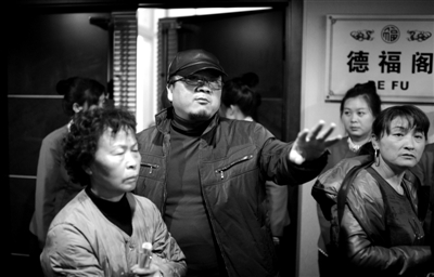 昨日，在河北香河天下第一城，相關負責人（左二）走出會議室與參加演出的老人們溝通。