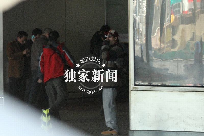 張默抵京機場過煙癮 神秘美女同車離去