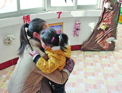 江都商貿(mào)幼兒園一位老師在擁抱該園的孩子。因?yàn)樯婕笆召M(fèi)，作為該園精品教育的一個(gè)項(xiàng)目，老師的擁抱行為也被質(zhì)疑。 董鑫 攝