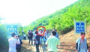 被困女子（圈中）獲救后從山嶺入口處豎有“軍事禁區(qū)”的標(biāo)牌旁通過。