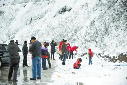 乘客在土山崗?fù)＼噮^(qū)休息時拍照賞雪。張磊攝