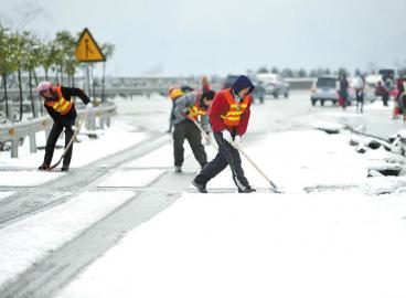 工作人員清理高速路上的積雪。 張磊攝
