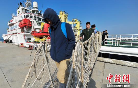 圖為24名“驢友”的“導(dǎo)游”被邊防的工作人員帶下船接受調(diào)查。 駱云飛 攝