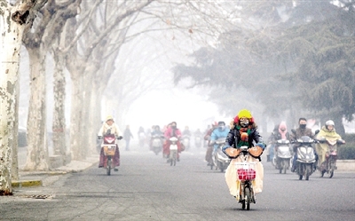 昨天上午，中原路，行人在霧霾中騎車出行，很多行人戴上了口罩。