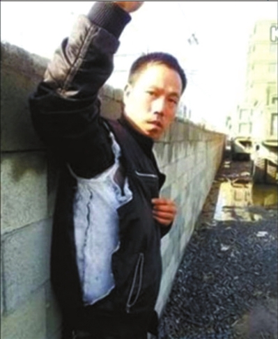 陳連弟向記者展示被撕壞的衣服。視頻截圖