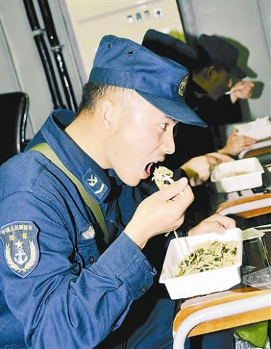 “青島”艦上的官兵在戰(zhàn)位上吃野戰(zhàn)快餐。解放軍報 記者 米晉國攝