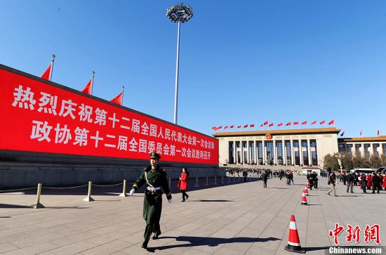 3月4日，北京晴空萬里，武警從北京天安門廣場大型顯示屏前走過。3月5日上午，十二屆全國人大一次會議將隆重開幕。中新社發(fā) 劉忠俊 攝