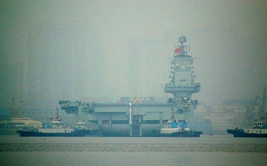 資料圖：大連港口大霧彌漫，中國首艘航母“遼寧艦”徐徐離開港口。
