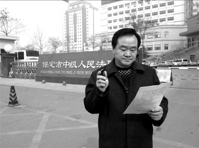 焦占軍在法院門(mén)口拿著決定書(shū)，無(wú)語(yǔ)站立。京華時(shí)報(bào)記者孫思婭攝