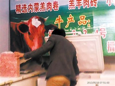 5月16日，新發(fā)地牛羊肉批發(fā)市場(chǎng)，商戶高佳從冰柜里取出10斤一兜的摻假羊肉，內(nèi)摻鴨肉。