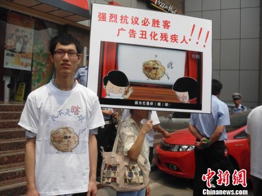 6月5日，視障人士在鄭州一必勝客門前舉牌抗議蝦球廣告歧視。 門杰丹 攝